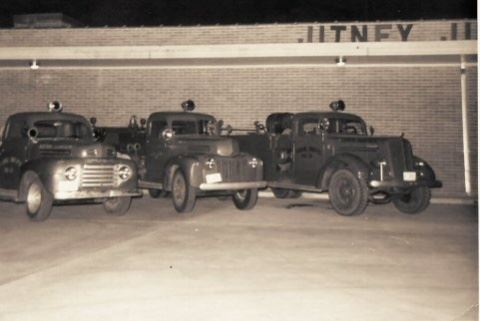 Three Old Fire Trucks in Front of Jitney Building
